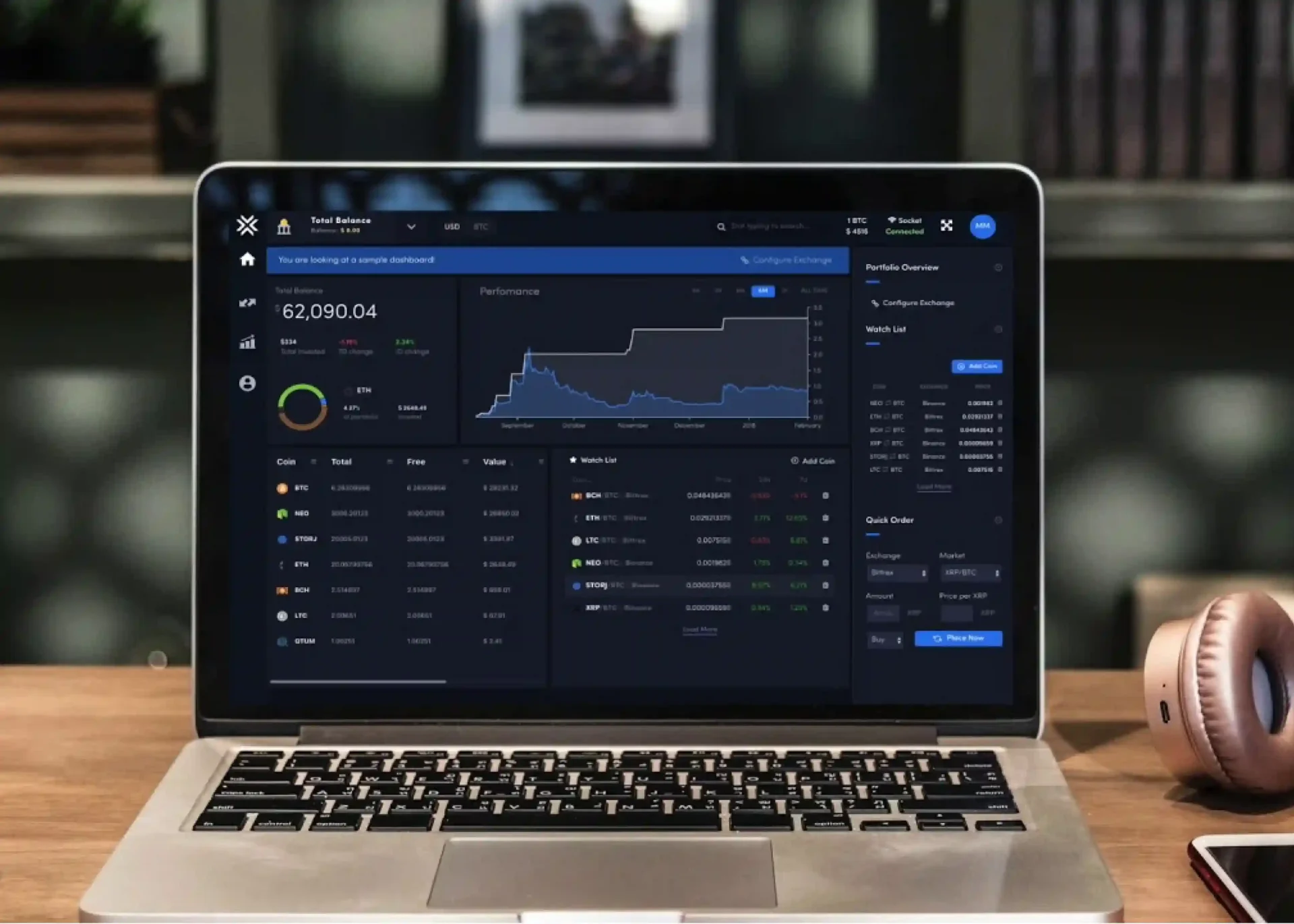 Laptop displaying a dark mode financial dashboard with charts, portfolio analytics, and trading data on a desk in a modern workspace.