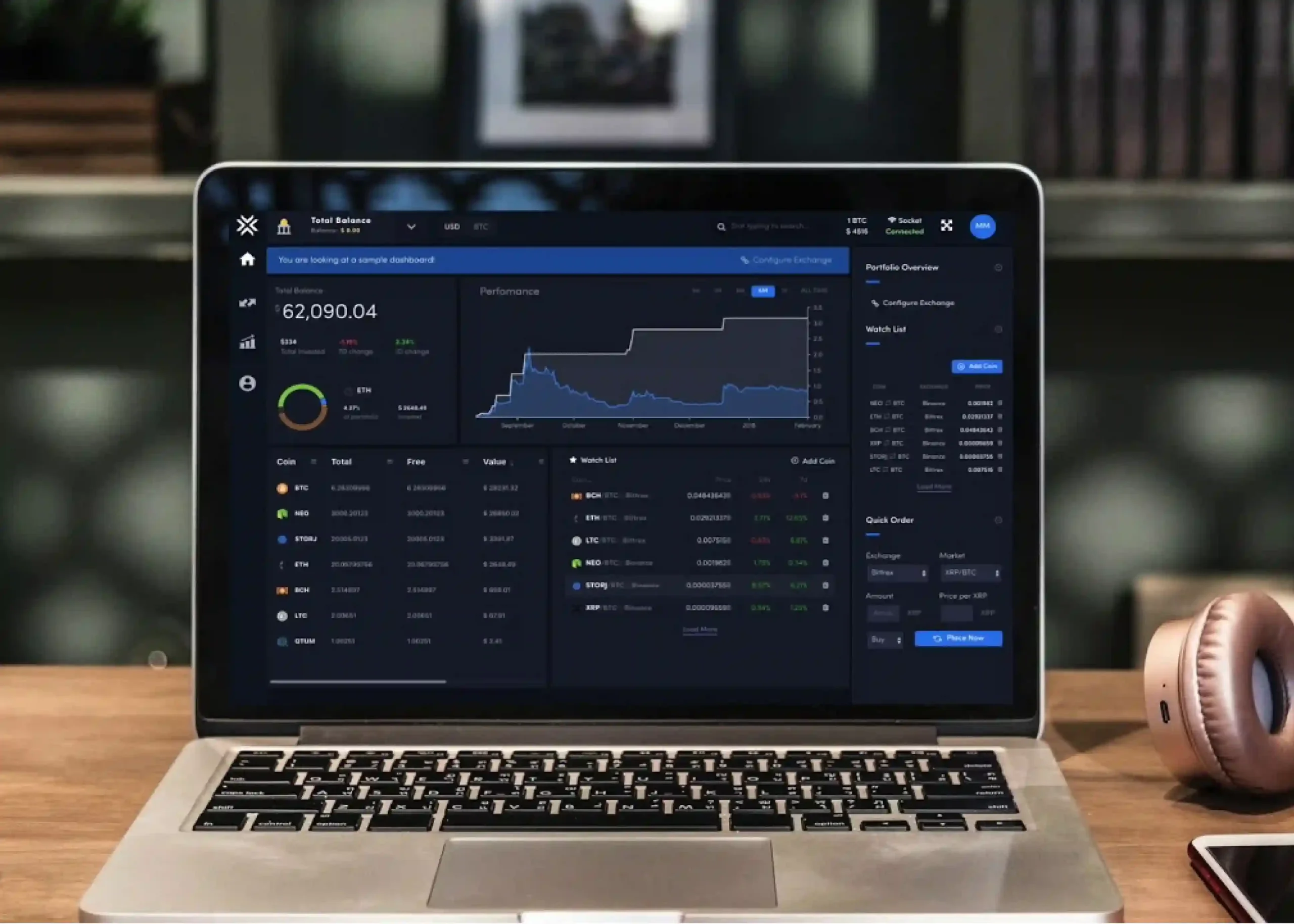 Laptop displaying a dark mode financial dashboard with charts, portfolio analytics, and trading data on a desk in a modern workspace.